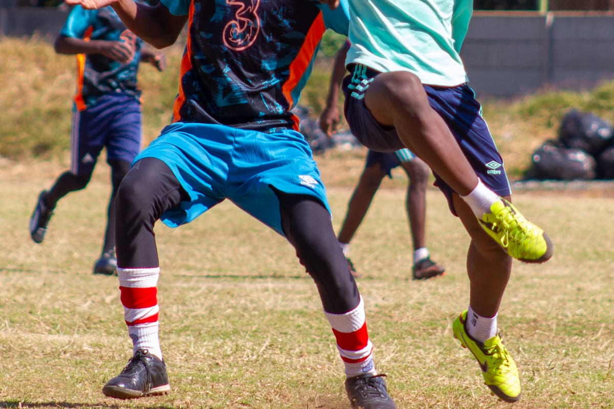 Secondary students contesting the ball in a football match